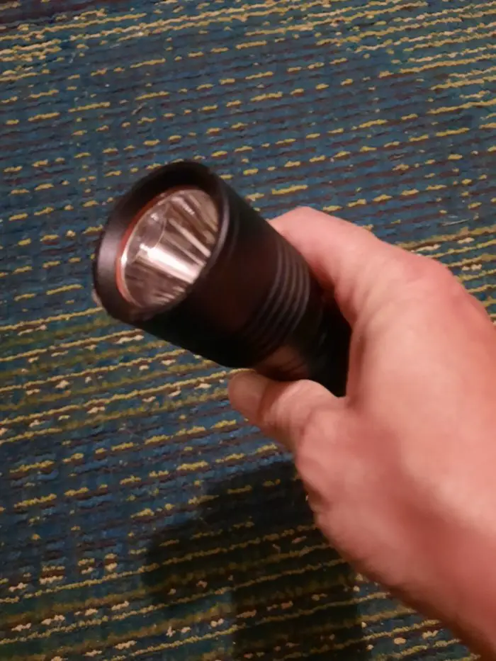 A hand holds a normal everyday flashlight