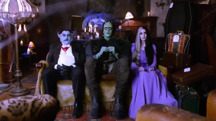 Grandpa, Herman, and Lily sit on the sofa in The Munsters