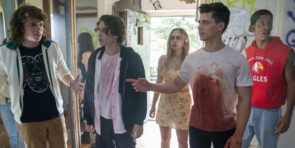 a blood covered Uriah Shelton exchanges words with Drew Schied while the rest of the cast stands behind them in Unhuman