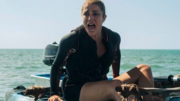 A woman sitting in a kayak in the ocean shouting