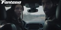 Rose and Teddy sit in a car and turn their bodies toward the back seat in Next Exit
