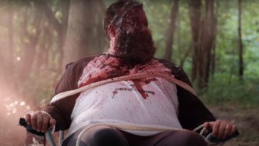 Matt sits tied to a chair covered in blood out in the woods in All Your Friends Are Dead