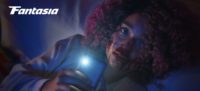 Cecilia sits, her face covered in blood, aiming her phone's flashlight toward the camera in Sissy
