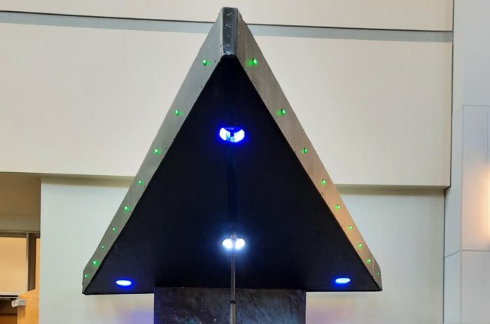 Triangular black photo opportunity set with lights.