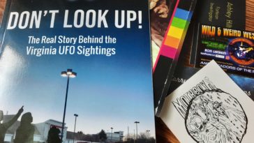 A book entitled "Don't Look up" and assorted cryptid enthusiasts' business cards.