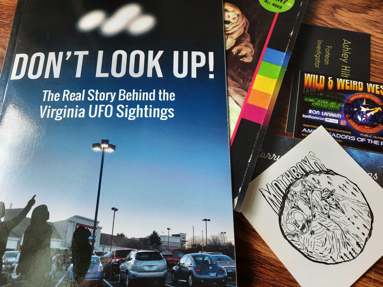 A book entitled "Don't Look up" and assorted cryptid enthusiasts' business cards.