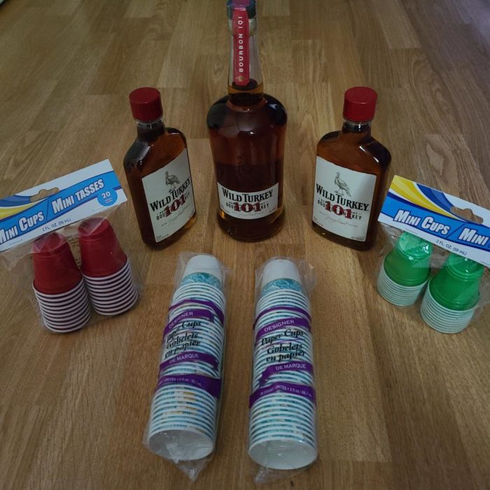 A picture of 3 bottles of Wild Turkey 101 and mini cups.