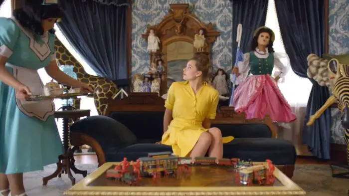 Coby wakes up in her new dollhouse surrounded by the dolls she will competing against