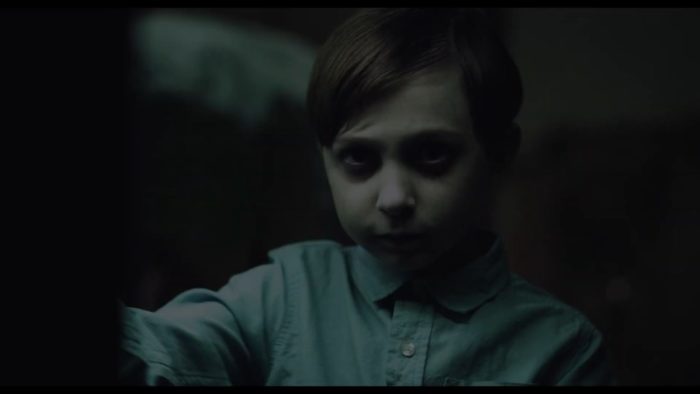 A young sickly looking boy looks straight into the camera in The Harbinger
