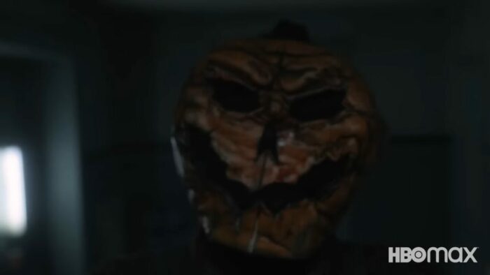 A walks around the party wearing a rotted pumpkin mask