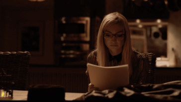 Jess Peters sits at a desk reading a screenplay