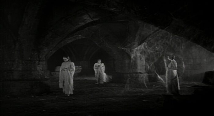 The three brides of Bela Lugosi's Dracula stalk from their coffins in the dark, dank crypt
