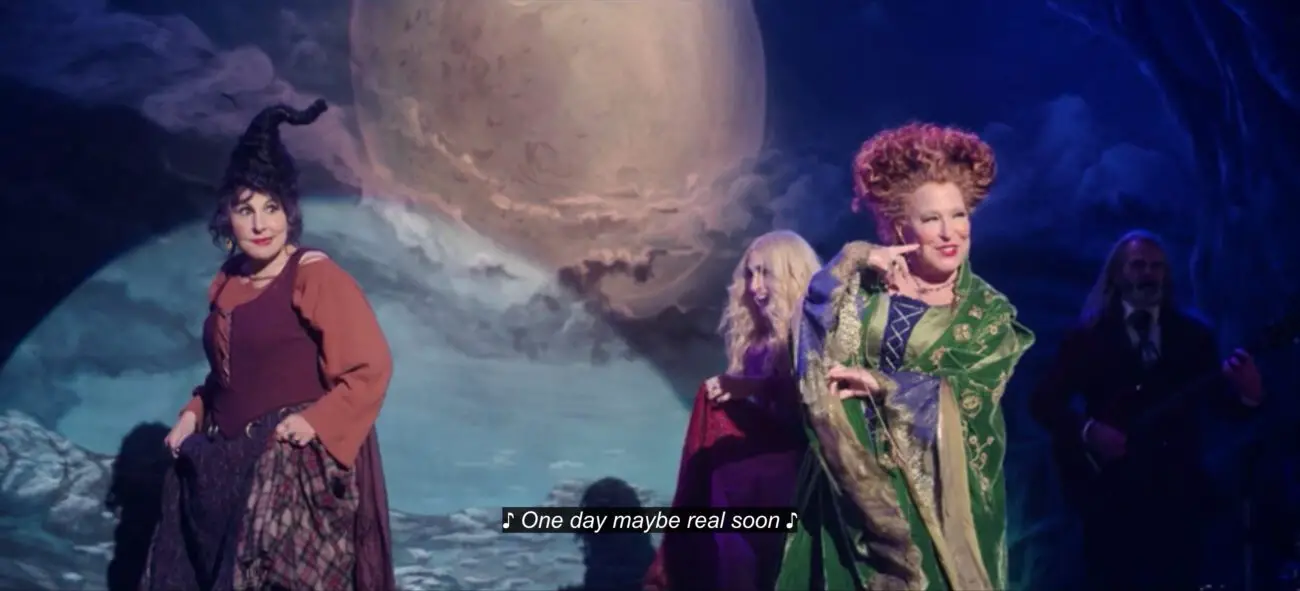 Winifred Sanderson (Bette Midler) sings, "One day maybe real soon," while dancing with Mary Sanderson (Kathy Najimy) and Sarah Sanderson (Sarah Jessica Parker), in the film, "Hocus Pocus 2" (2022).