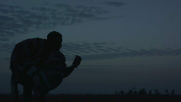 Chaka (Yann Gael) hunches in the twilight clutching a revolver and a handful of earth