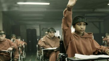 A girl in classroom raises her hand.
