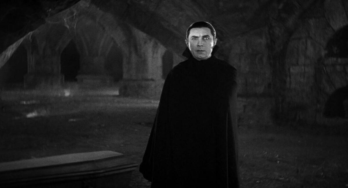 Bela Lugosi's Dracula stands in a crypt, his cape wrapped around him, and his eyes glowing white