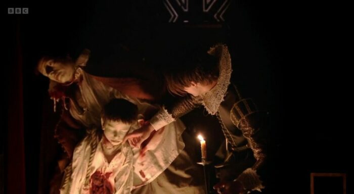 Ferdinand strokes the cheek of a wax figure of his dead nephew
