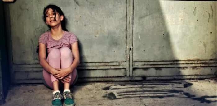 Estrella, played by Paolo Lara, sits on the cold concrete floor looking desperate and afraid