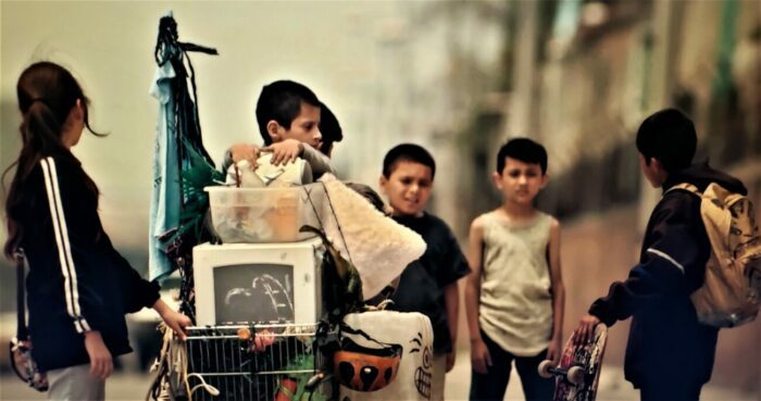 A group of Mexican orphans wandering the streets alone, pushing a shopping cart full of their meager possessions.