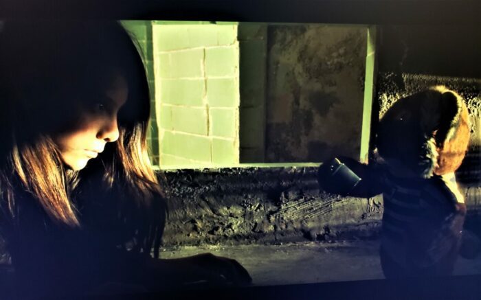 a plush toy tiger come to life offers a lighter to Estrella, a young girl.