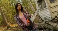 Marjorie (Eva Hamilton) stands holding a chainsaw in the movie Sawed Off