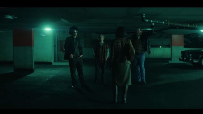 A group of people meet at an underground parking garage 