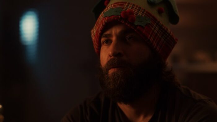 Dylan looks puzzled while wearing a festive holiday hat in Breathing Happy