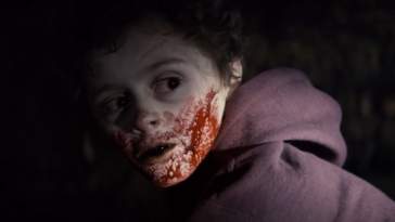 A vampire kid with blood on his face.
