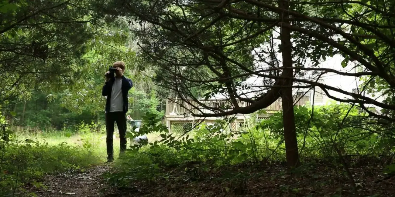 A man filming in his backyard