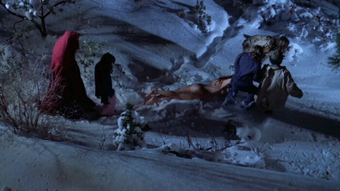 a group of children drag a woman's naked body through the show