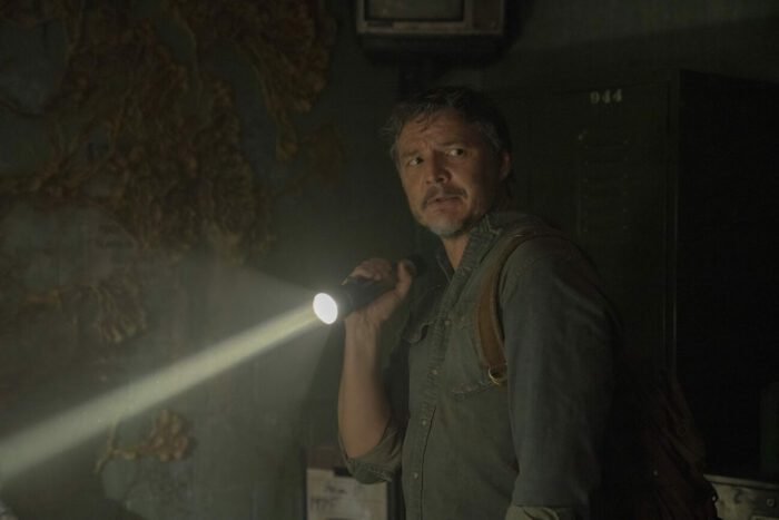Joel shines a flashlight in a dark room in The Last of Us episode 1 “When You’re Lost in the Darkness.”