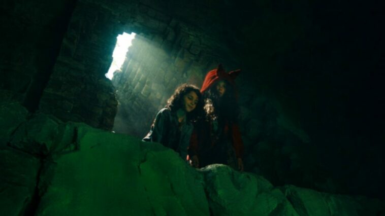 Spencer and Lucy stand over a green glowing precipice in There's Something Wrong with the Children