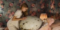 Tinja kneeling next to her gigantic egg