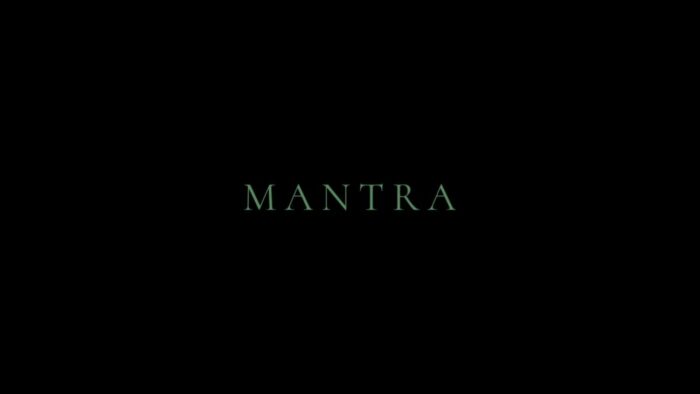 Title card for Mantra, blueish text spells "Mantra" overlayed on a black background