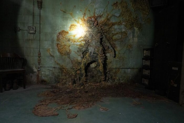 A Cordyceps infected person is fused to a moldy wall in the flashlight glow in The Last of Us episode 1, "When You’re Lost in the Darkness.”