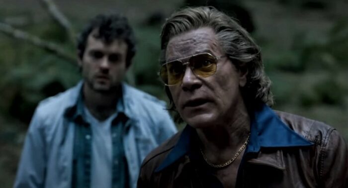 Ray Liotta and Alden Ehrenreich in the woods searching for drugs in Cocaine Bear.