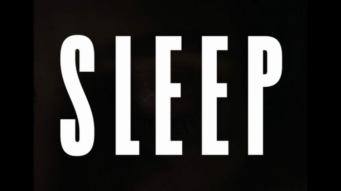 Title card for Sleep, white text spells "Sleep" overlayed on an image of someone sleeping