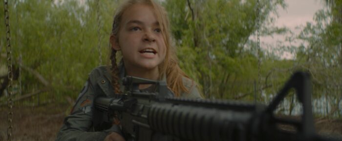 A girl holding a gun and looking intense