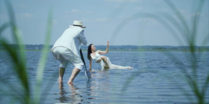 A man takes pictures of a woman in the water