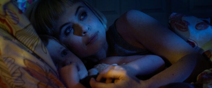 Sara lies down with her daughter Emma in the moonlight in Moon Garden