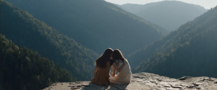 Mira and Šarlota embrace on a scenic cliffside in Nightsiren.