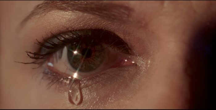 a close-up of a woman's eye as a tear forms.