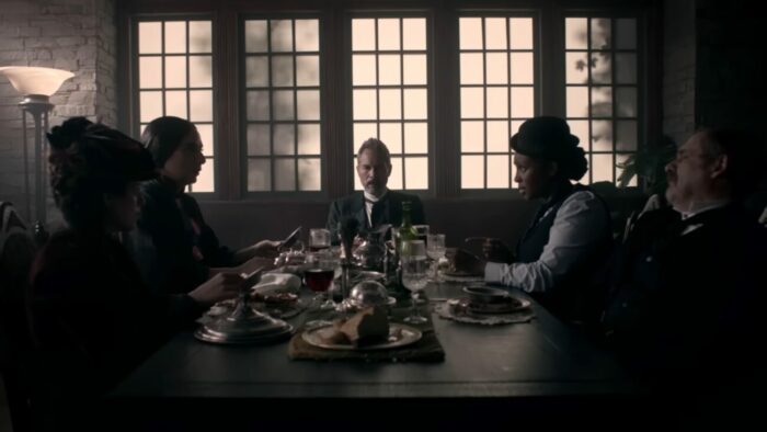 The remaining people from the photograph sit around a table for lunch and a discussion.