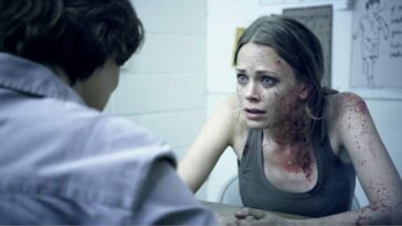 Anne Roland, Katia Winter, speaks to someone whilst covered in blood.