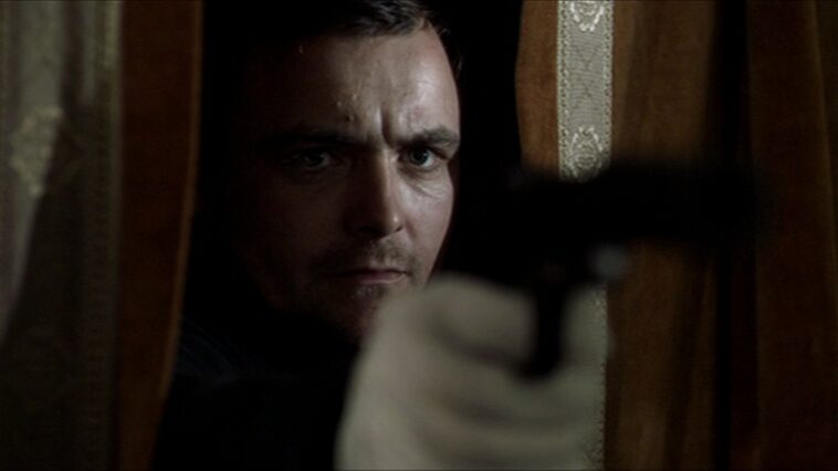 Jay, Neil Maskell, takes aim with a silenced pistol.