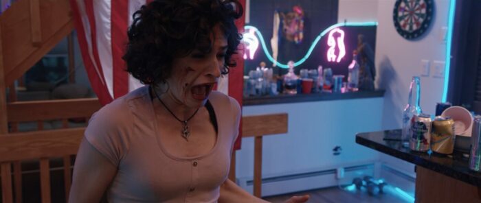 Mary stands in a kitchen screaming in Guys At Parties Like It