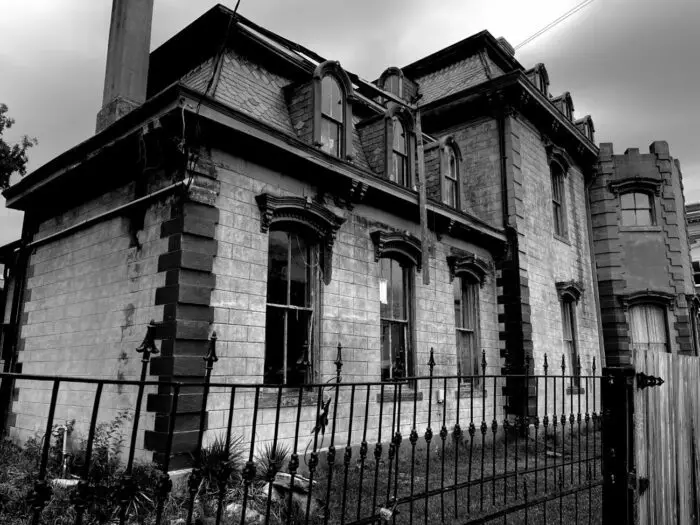 A creepy turn-of-the-century mansion in stark black and white.