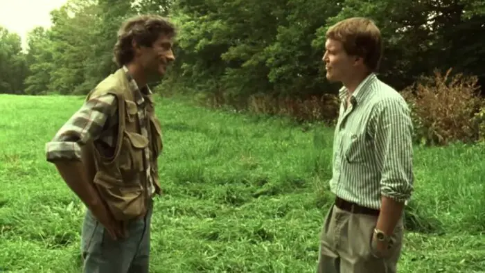 Geoffrey and Alix talk in a field