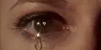 An Eyeball glistens in the light with a tear rolling down its cheek in Tearsucker
