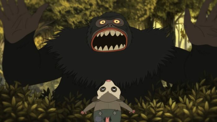 A wild gorilla appears behind a bush, frightening a possum